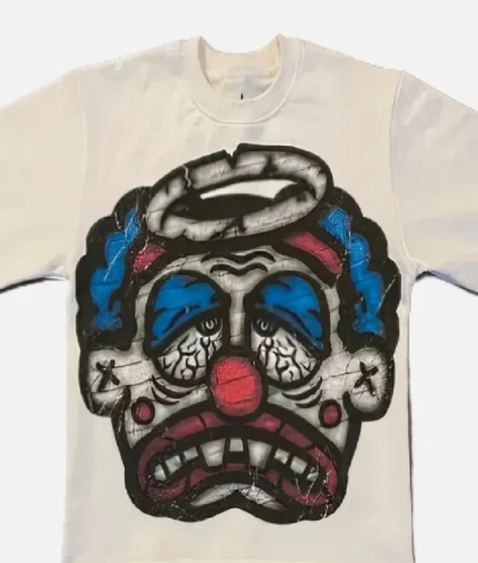 Billionaire Studios Sad Jocker Face Blue Logo Tee Cream front view Close-up of Sad Jocker face blue logo on Billionaire Studios tee Side profile of cream-colored Billionaire Studios graphic t-shirt Model wearing Billionaire Studios Sad Jocker Face Blue Logo Tee Cream