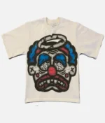 Billionaire Studios Sad Jocker Face Blue Logo Tee Cream front view Close-up of Sad Jocker face blue logo on Billionaire Studios tee Side profile of cream-colored Billionaire Studios graphic t-shirt Model wearing Billionaire Studios Sad Jocker Face Blue Logo Tee Cream